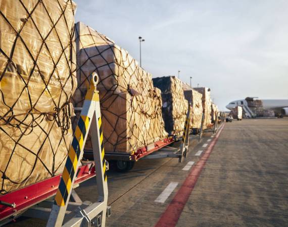 Loading of cargo containers to airplane at airport.